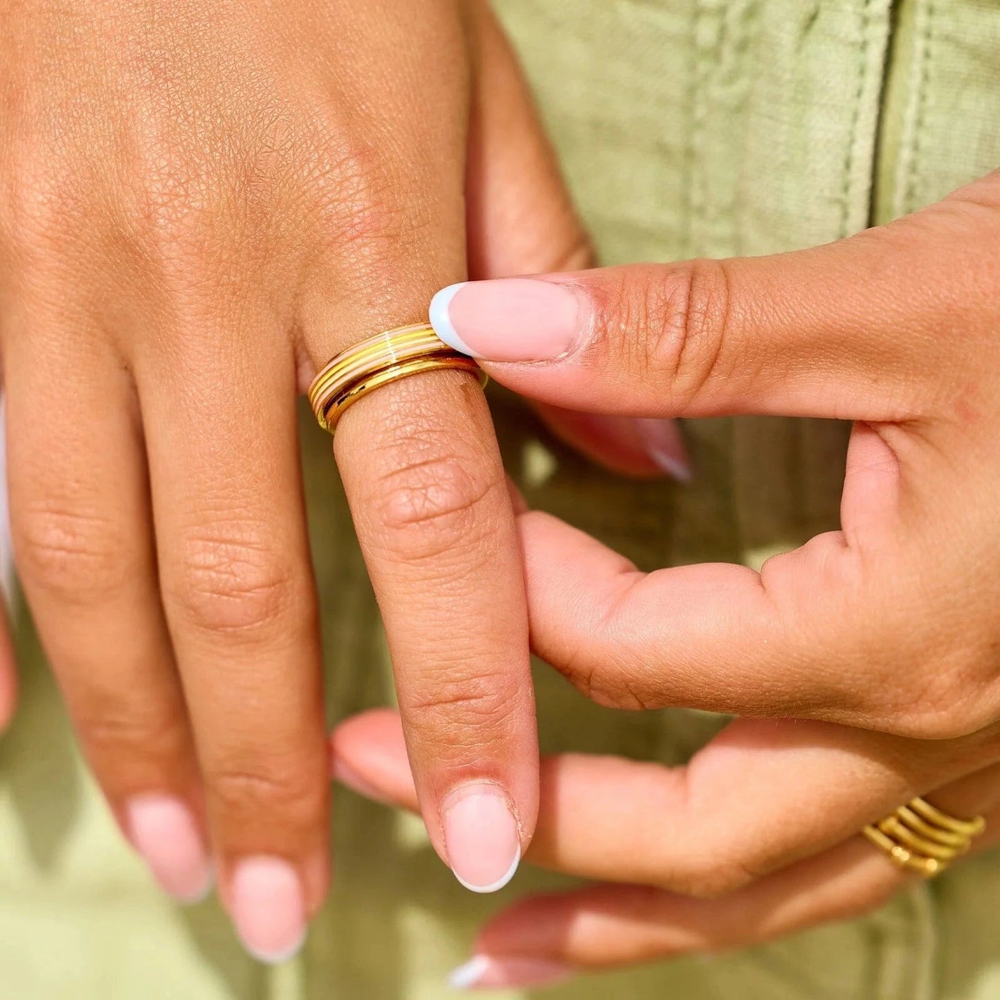 Close-up of hands with gold rings on a blurred background