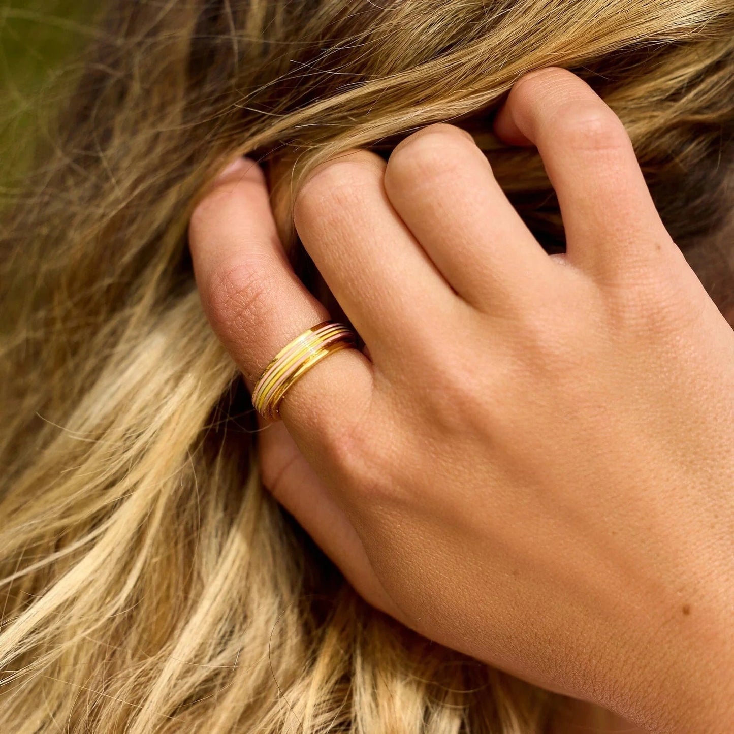 Hand with a gold ring on a blurred background