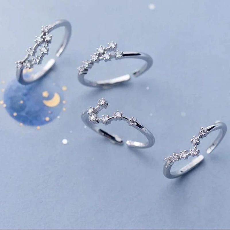 Set of silver rings with star designs on a light blue background(Zodiac ring)