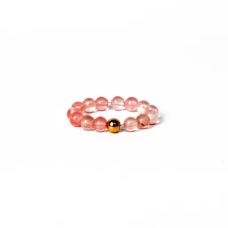 Beaded ring with pink and gold beads on a white background