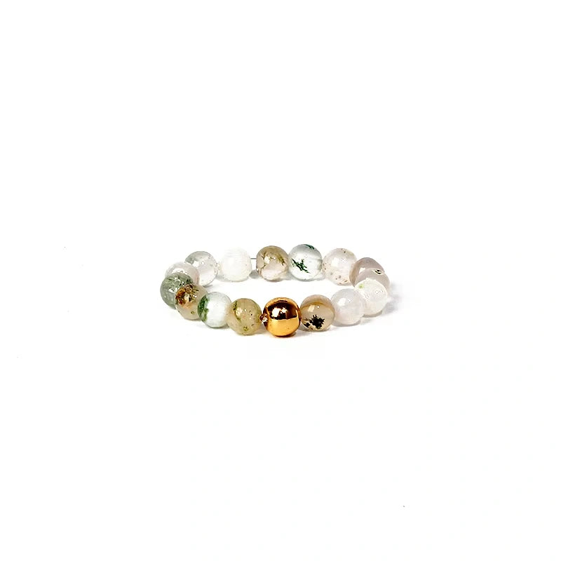 Beaded ring with gold and silver accents on a white background