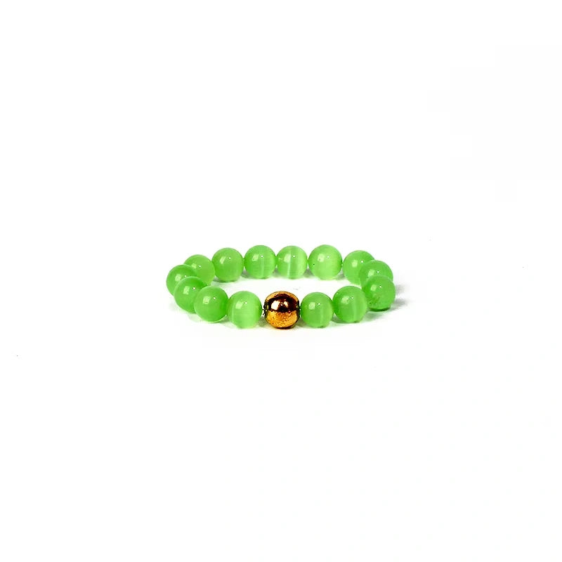 Green beaded ring with a gold accent on a white background