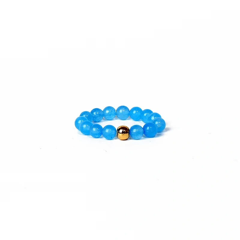 Blue beaded ring with a gold accent on a white background