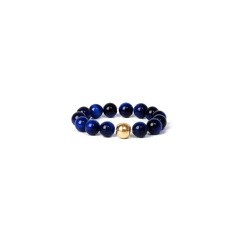 Blue beaded ring with a gold accent on a white background