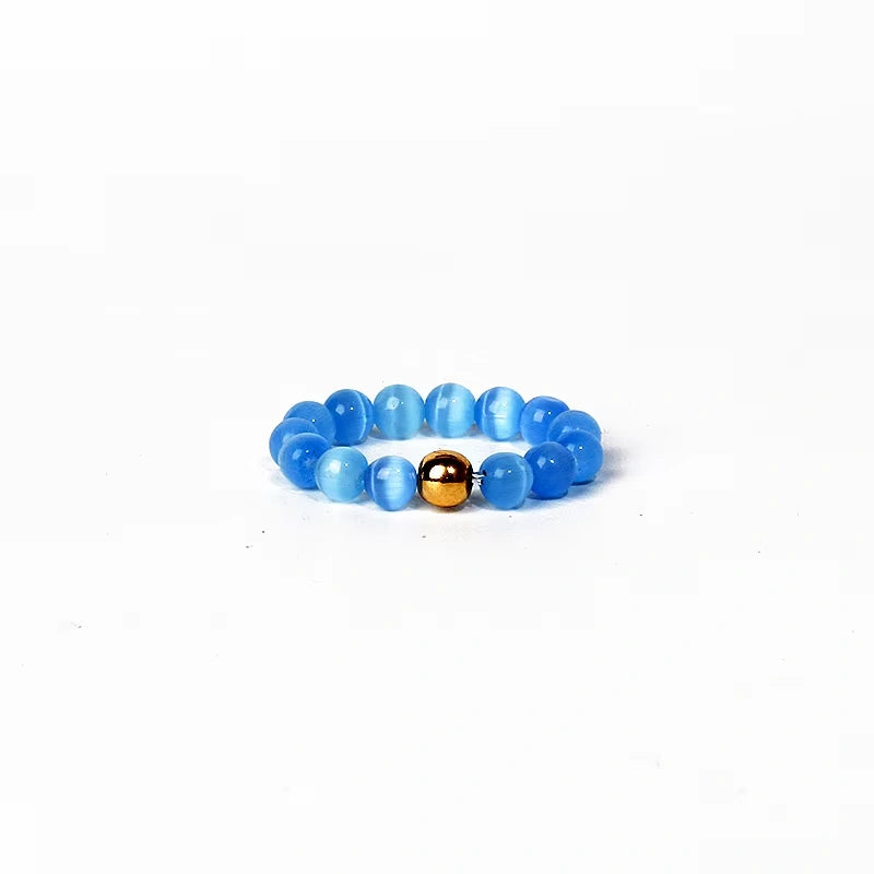 Blue beaded ring with a gold bead on a white background