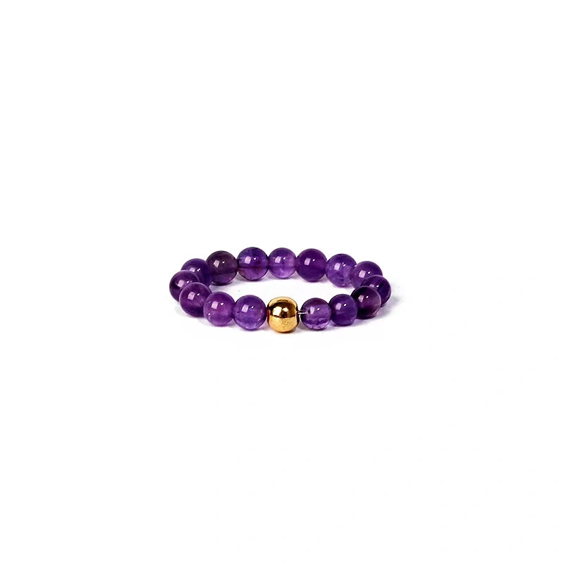 Purple beaded ring with a gold accent on a white background