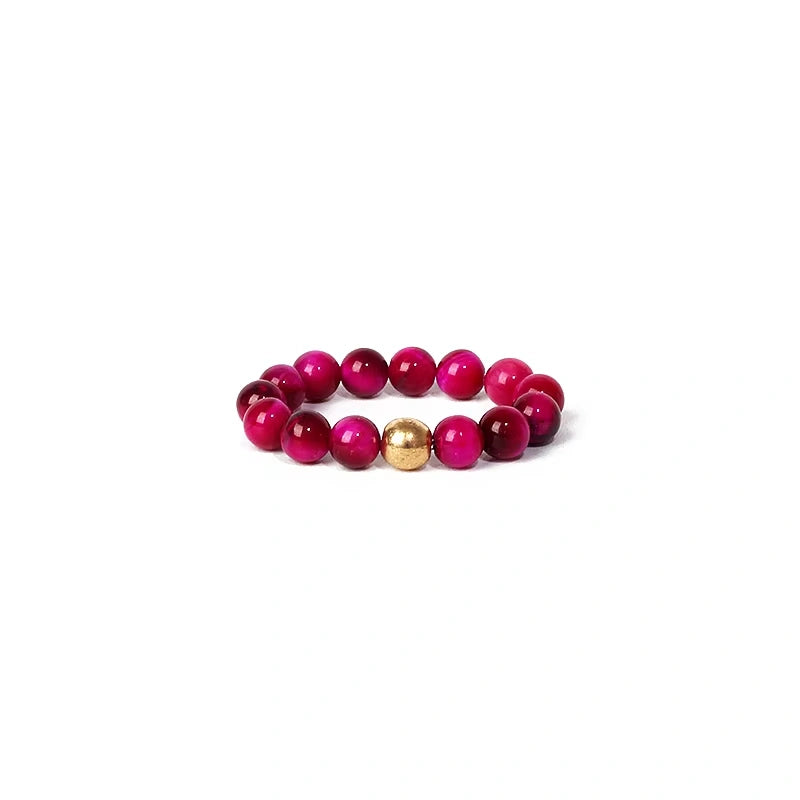 Beaded ring with pink and gold beads on a white background