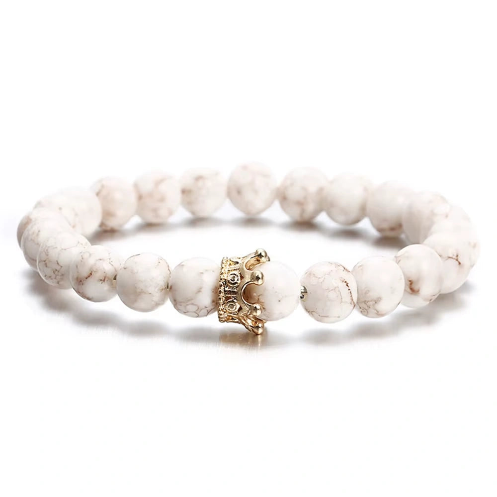 White beaded bracelet with a gold clasp on a white background