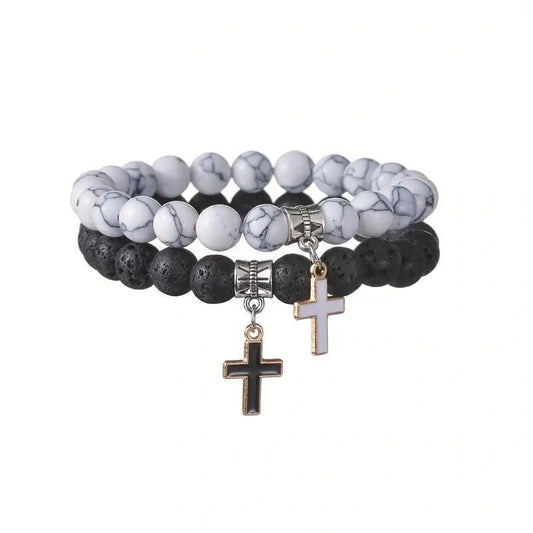 Bracelet with black and white marbled beads and cross charms on a white background