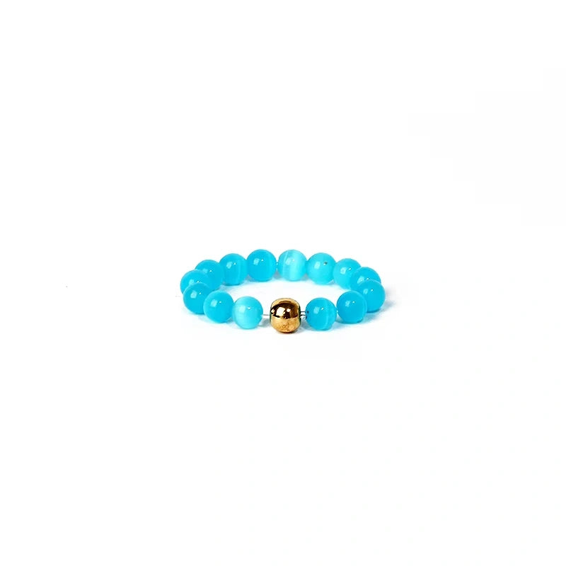 Turquoise beaded ring with a gold accent on a white background
