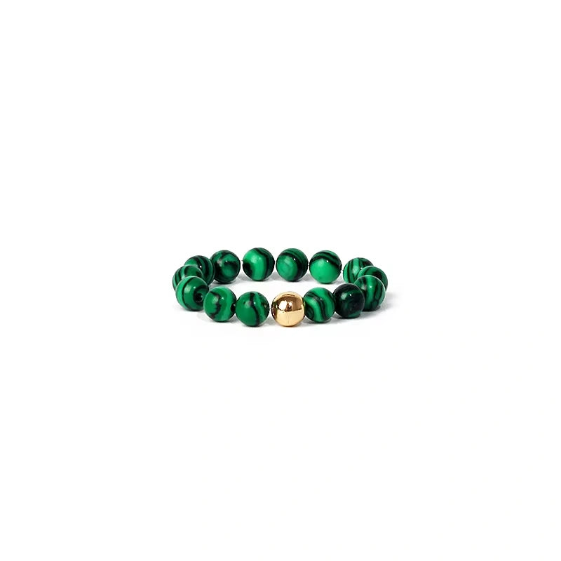 Green beaded ring with a gold accent on a white background