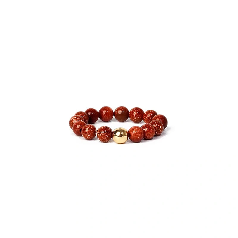 ring with red beads and a gold bead on a white background