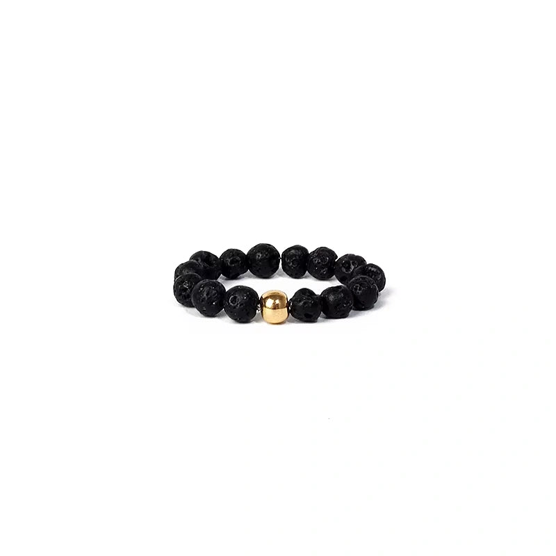 Black beaded ring with a gold accent on a white background