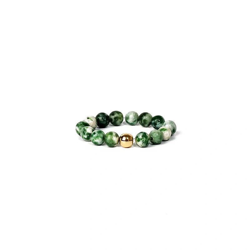 Green beaded ring with a gold accent on a white background