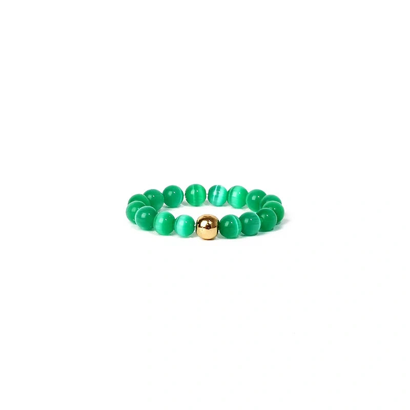 Green beaded ring with a gold accent on a white background