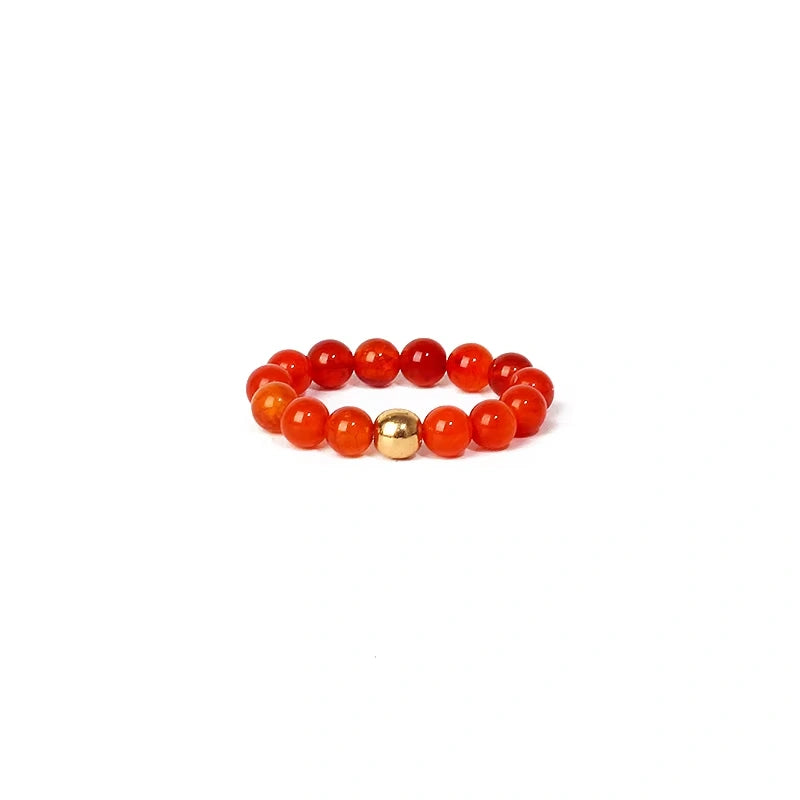 ring with red beads and a gold bead on a white background