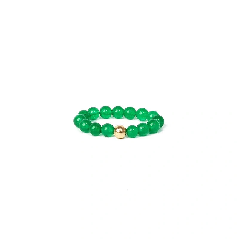 Green beaded ring with a gold accent on a white background