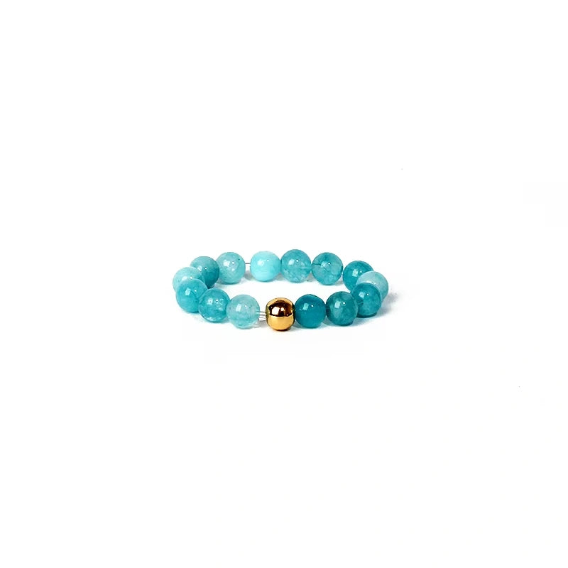 Turquoise beaded ring with a gold accent on a white background