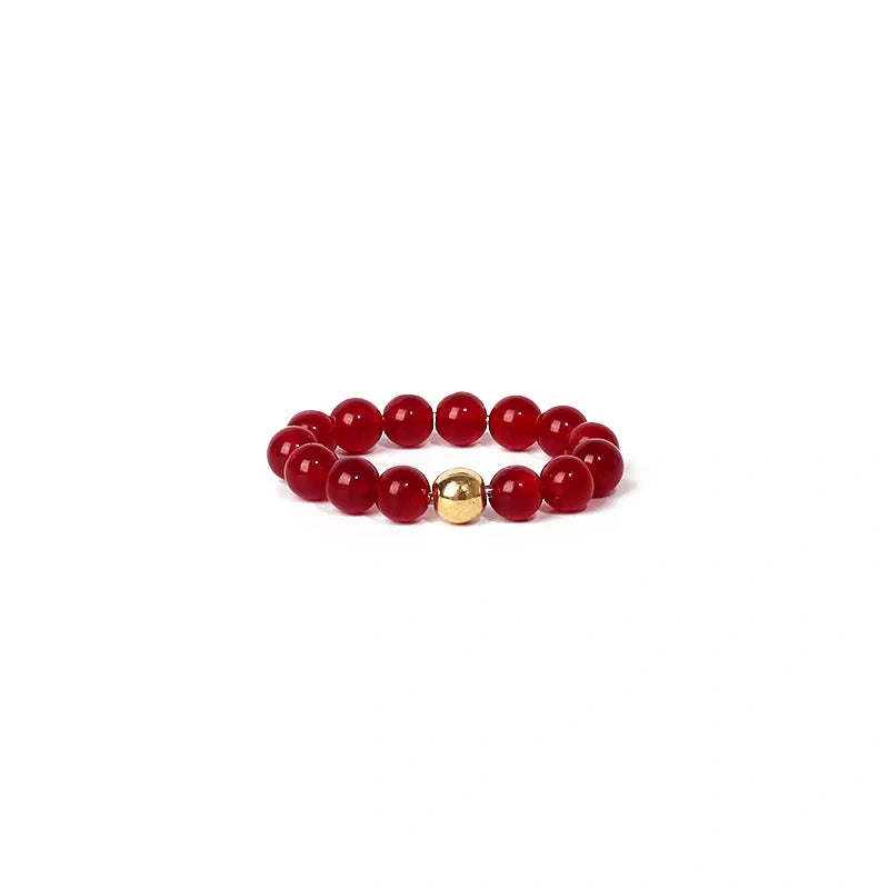 Red beaded ring with a gold accent on a white background