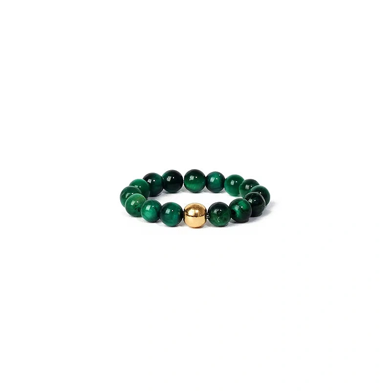 Green beaded ring with a gold accent on a white background